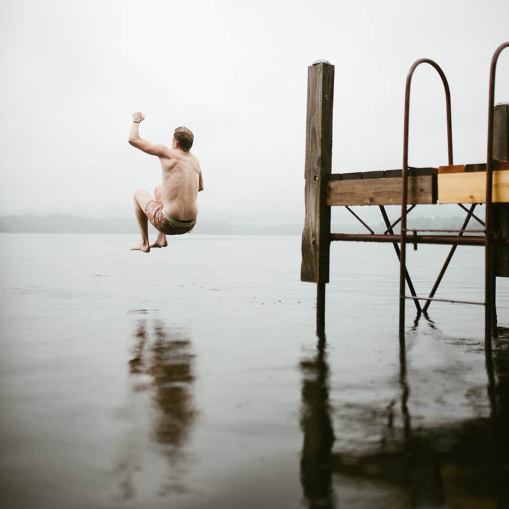 A man jumping into a lake to cool down after a sauna session